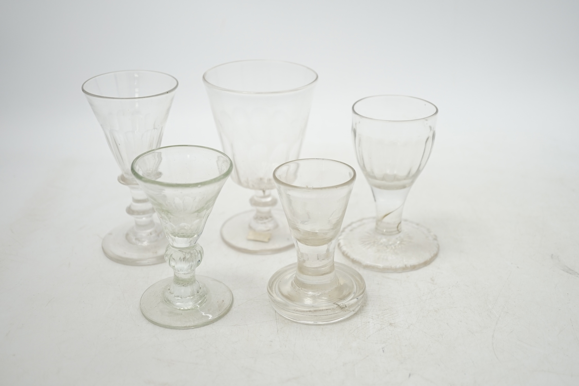 A mid 18th century wine glass with over-sewn foot and four others, three with knopped stems, tallest 10.5cm. Condition - good